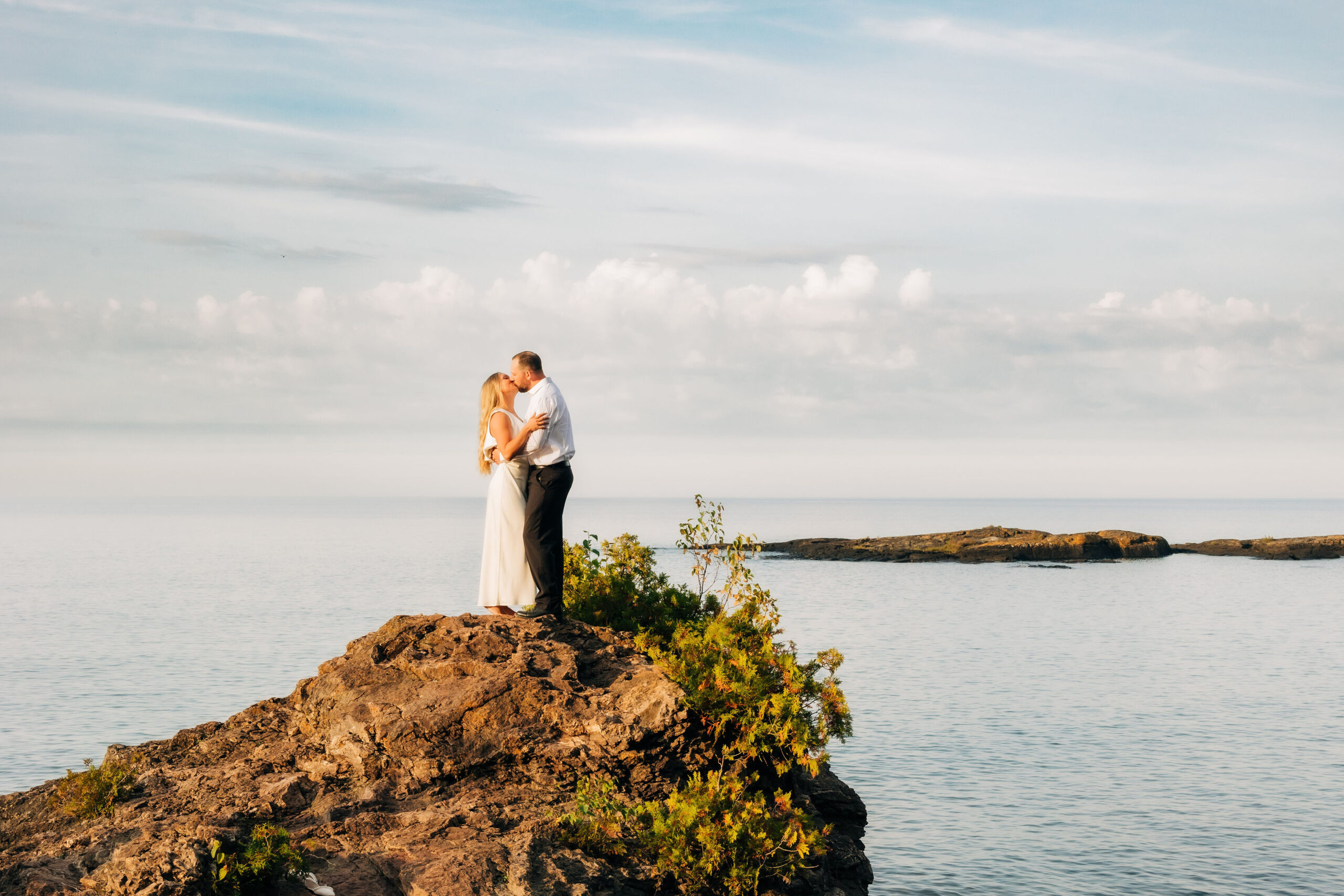 Man and woman standing on cliff edge on lake superior
