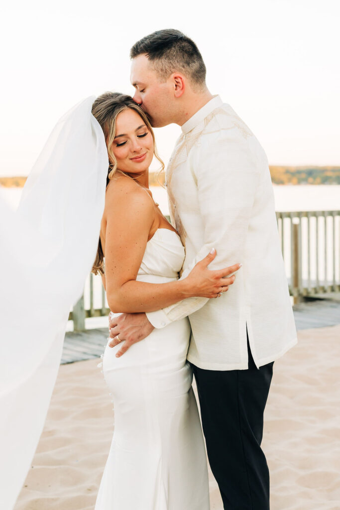 Couple embracing in sunset after marriage ceremony