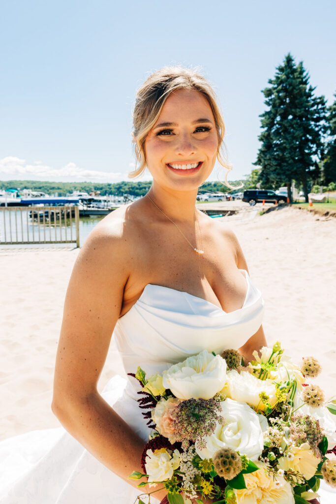 Bride smiling for camera holding bouquet