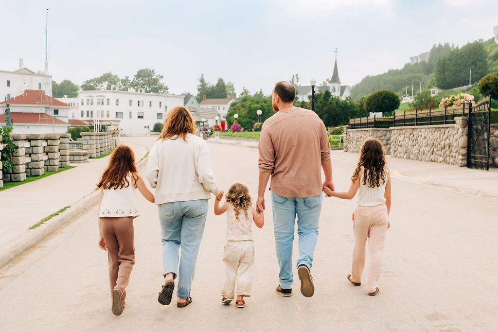 family holding hands walking downtown oon Mackinac Island