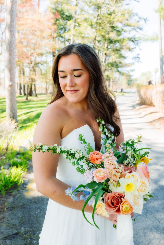 Bride with long brown hair wearing dress and holding bouquet of flowers