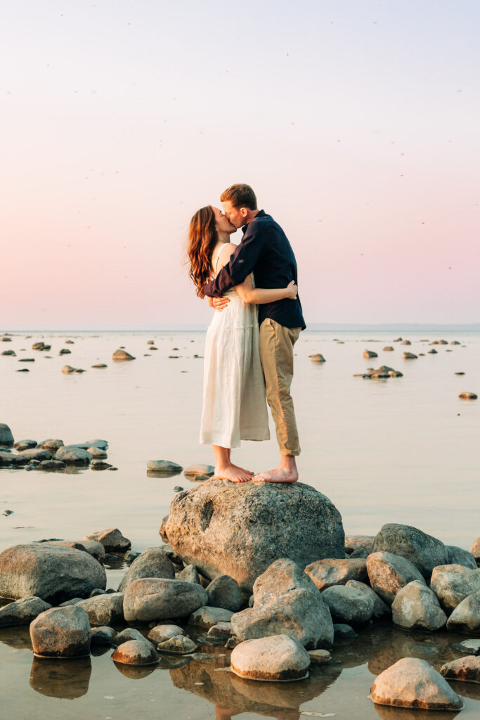 Couple standing on rocks at Old mission lighthouse 